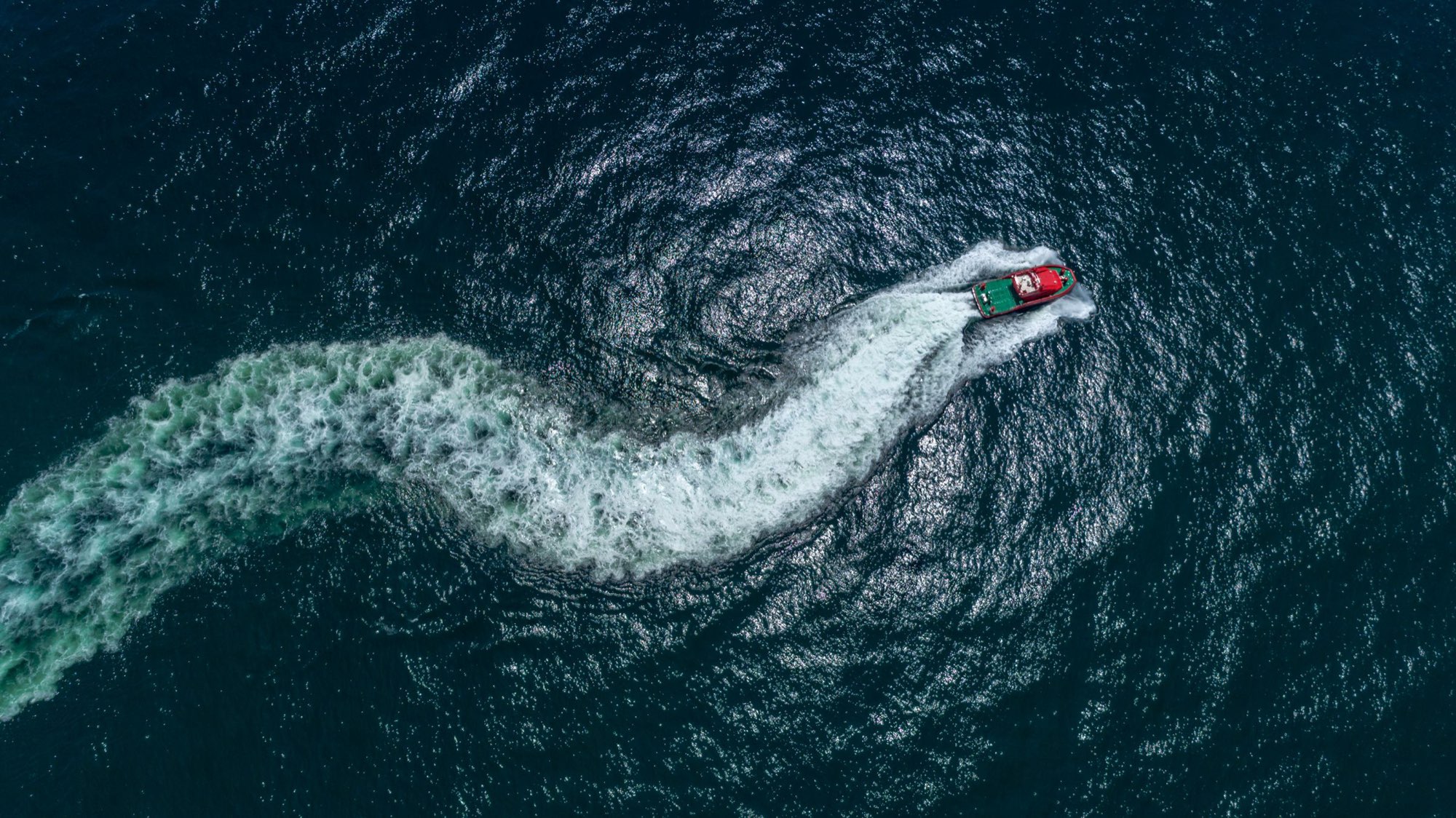 Aerial view of a boat carving an S-curve wake